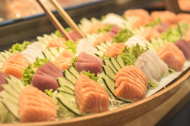 Large portion of salmon, whitefish and tuna sashimis with same cucumber. - Photo, Image