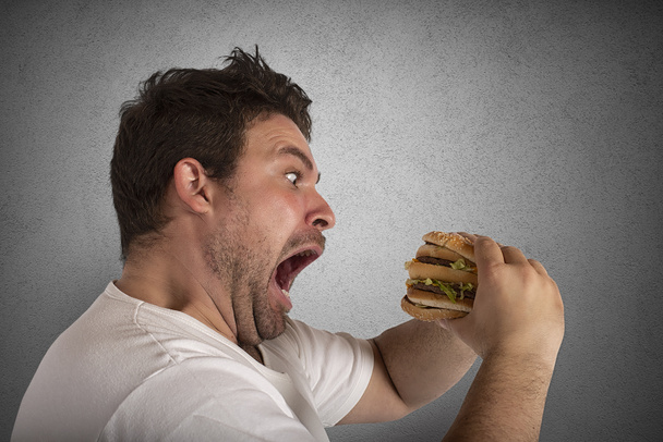 Insatiable and hungry man eating a sandwich - Photo, Image
