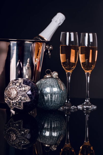 シャンパン、酒瓶と黒の背景のクリスマス飾り 2 つのワイングラス。領域をコピーします。メリー クリスマスと新年あけましておめでとうございます、背景 - 写真・画像