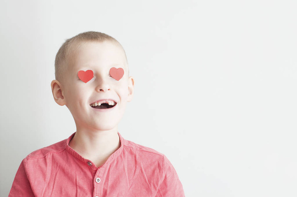Happy boy with heart shape loving look on white background - Foto, afbeelding