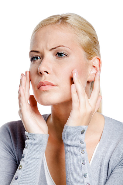 Woman examining her face and wrinkles that can appear, isolated on white - Photo, Image