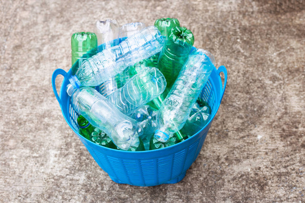 Πλαστικά μπουκάλια στο μπλε καλάθι αποβλήτων. - Φωτογραφία, εικόνα