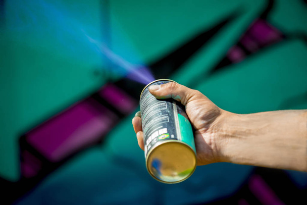 человек рисует граффити панель с голубой кистью чернил
 - Фото, изображение