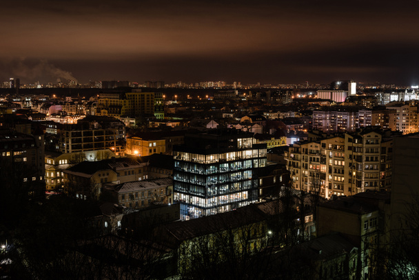 paisagem urbana com iluminação brilhante em janelas de edifícios
 - Foto, Imagem