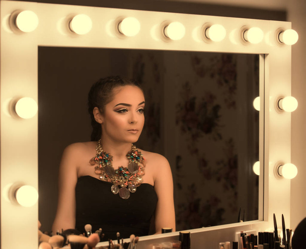 Teenage Girl Looking at Mirror Applying Make-up - 写真・画像