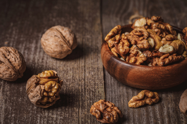 close up view of walnuts in bowl on wooden surface - Photo, Image