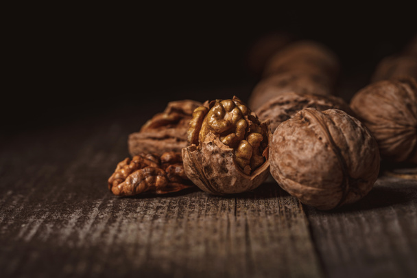 close up view of shelled and whole walnuts on wooden tabletop - Valokuva, kuva