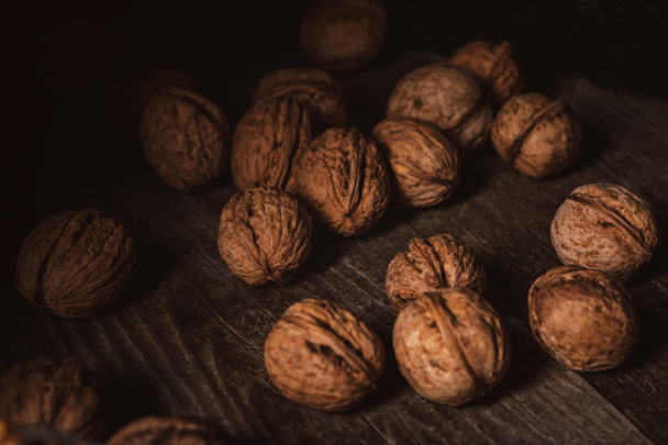 close up view of walnuts in husk on wooden table - Фото, зображення