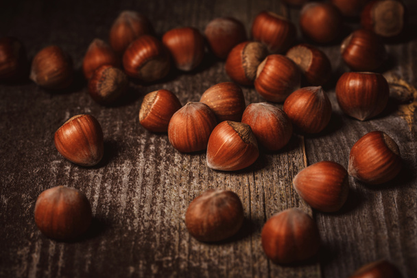 close up view of shelled hazelnuts on wooden backdrop - 写真・画像