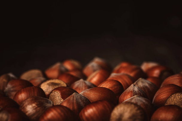 close up view of shelled hazelnuts on black background - 写真・画像