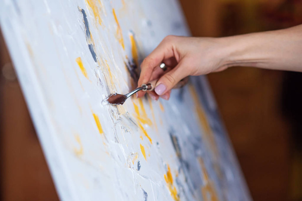 The artist paints an abstract painting using mastichin. - Foto, imagen