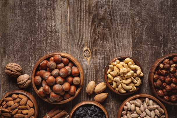 top view of nuts in bowls arranged on wooden tabletop - Photo, Image