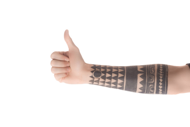 частковий вид татуйованого чоловіка, що показує великий палець знак вгору ізольовано на білому
 - Фото, зображення