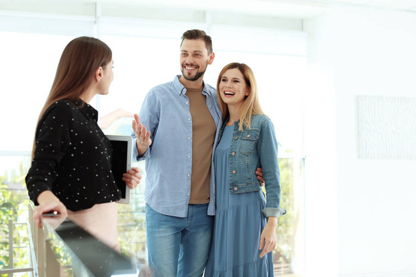 Female real estate agent showing new house to couple, indoors - Photo, Image