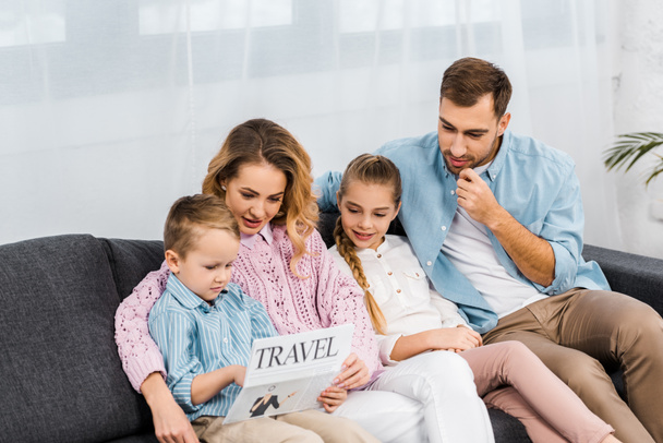 семья сидит на диване и читает туристическую газету в гостиной
 - Фото, изображение