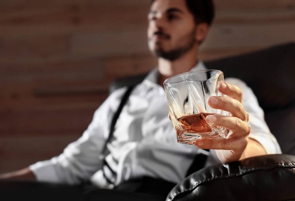 Man with glass of whiskey sitting in armchair, closeup. Space for text - Fotó, kép