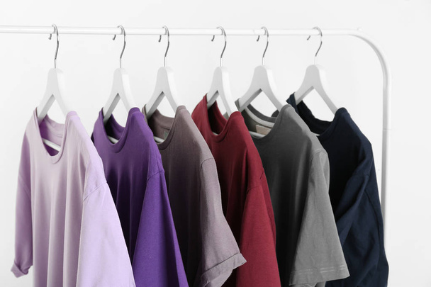 Men's clothes hanging on wardrobe rack against white background - Foto, afbeelding