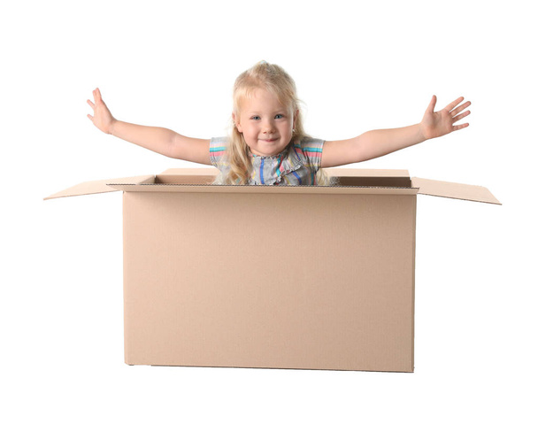 Cute little girl playing with cardboard box on white background - Φωτογραφία, εικόνα