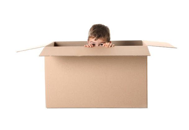 Cute little boy playing with cardboard box on white background - Φωτογραφία, εικόνα