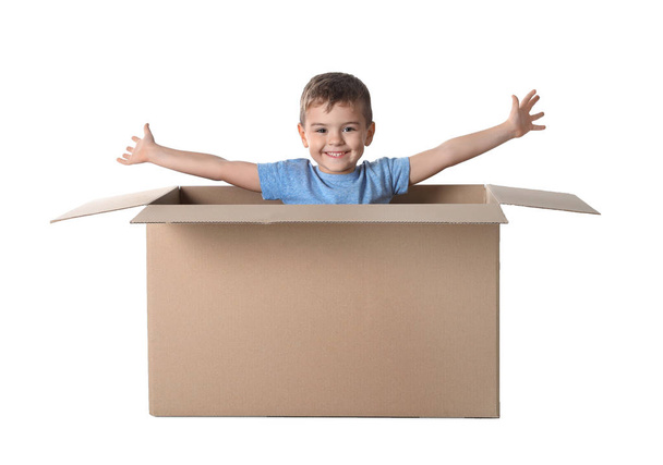 Cute little boy playing with cardboard box on white background - Foto, Imagen