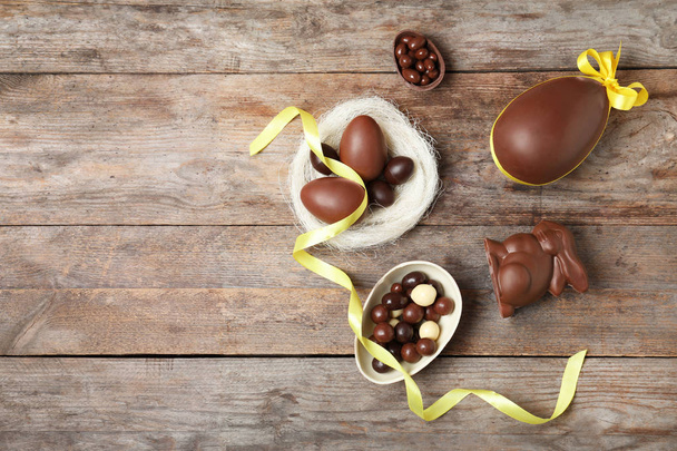 Flat lay composition with chocolate Easter eggs and space for text on wooden background - Foto, Imagem