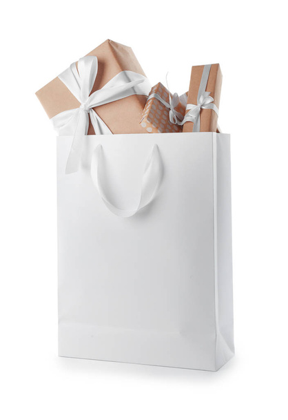 Paper shopping bag with handles full of gift boxes on white background. Mock up for design - Photo, image