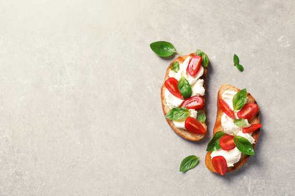 Toasted bread with tasty cream cheese and tomatoes on gray background, flat lay. Space for text - Foto, imagen