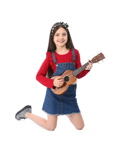 Маленька весела дівчинка грає на гітарі, ізольована на білому
 - Фото, зображення
