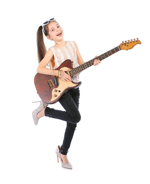 Little cheerful girl in mother's shoes playing guitar, isolated on white - Fotografie, Obrázek