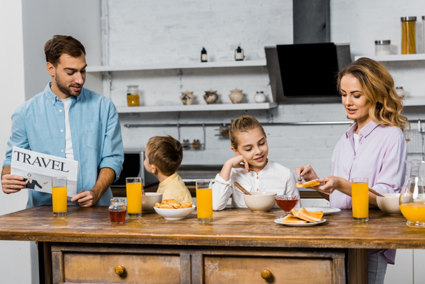Szczęśliwa rodzina o śniadanie z grzankami, pliki cookie i sok pomarańczowy w rano - Zdjęcie, obraz