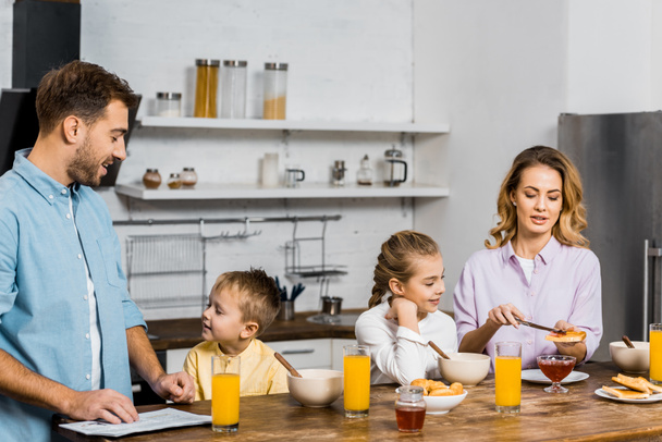 happy family having breakfast at table in kitchen - Фото, зображення