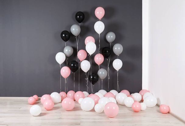 Room decorated with colorful balloons near wall - 写真・画像