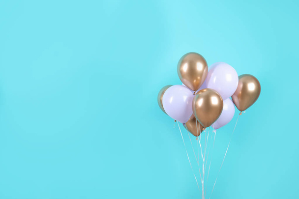 Colorful party balloons on blue background. Space for text - 写真・画像
