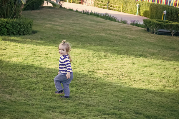 Boy with blond hair run on green grass - Foto, Bild