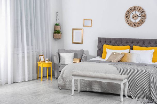 Stylish room interior with large comfortable bed - Zdjęcie, obraz
