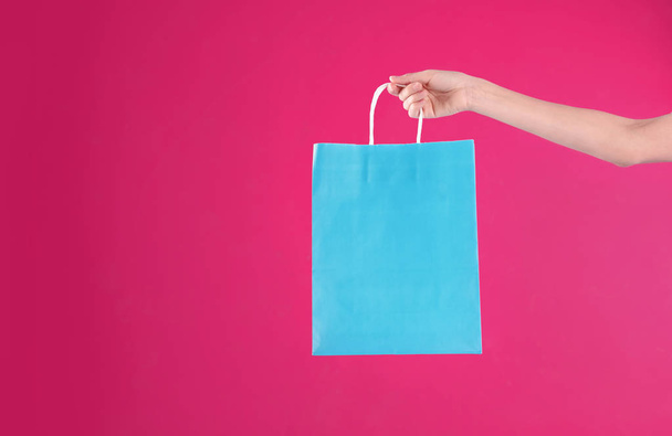 Woman holding shopping bag on color background, closeup.  Mock-up for design - Фото, зображення