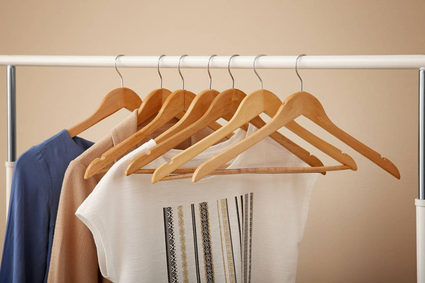 Female clothes on wardrobe rack on color background - Photo, Image