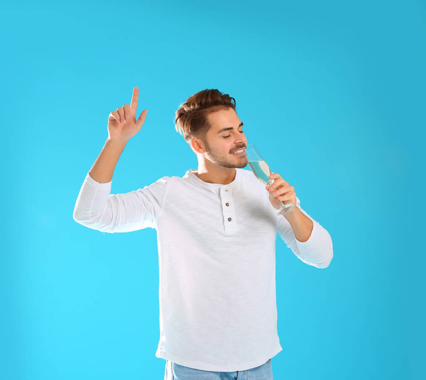 Portrait of happy man with champagne in glass on color background - Foto, Imagem