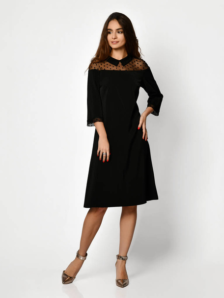 Young beautiful woman posing in new black fashion winter dress full body on a white  - Foto, afbeelding