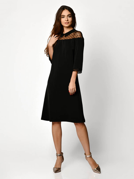 Young beautiful woman posing in new black fashion winter dress full body on a white  - Photo, Image