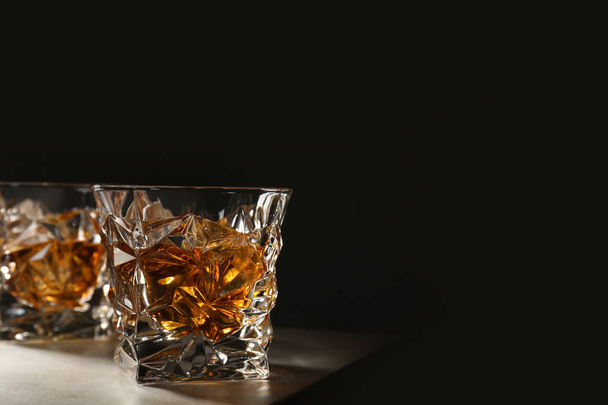 Golden whiskey in glass with ice cubes on table. Space for text - 写真・画像