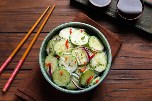Dish with fresh creamy cucumber salad served on wooden background - Fotó, kép