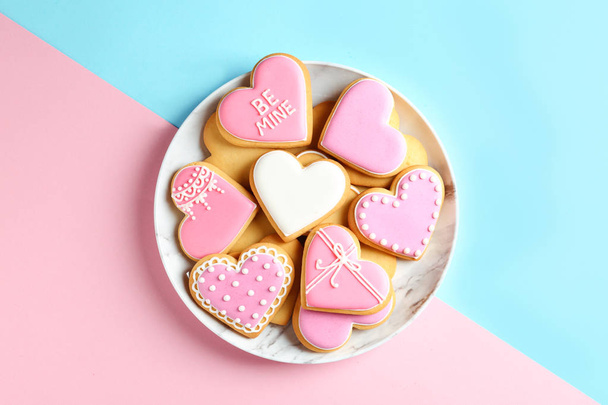 Plate with decorated heart shaped cookies on color background, top view - Fotoğraf, Görsel