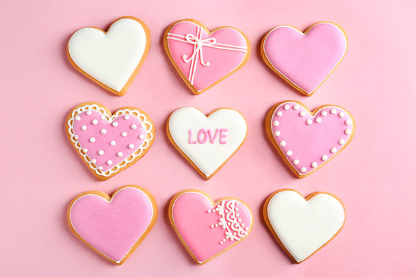 Decorated heart shaped cookies on color background, flat lay. Valentine's day treat - Фото, зображення