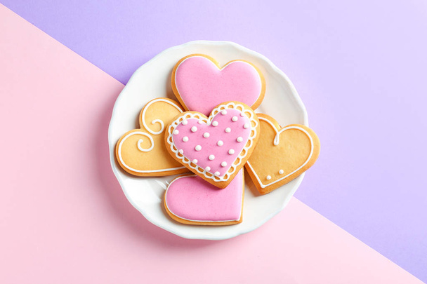 Plate with decorated heart shaped cookies on color background, top view - Zdjęcie, obraz