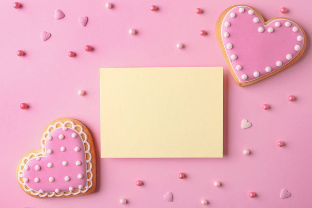 Плоская композиция с печеньем в форме сердца и пустой карточкой на цветном фоне, место для текста
 - Фото, изображение