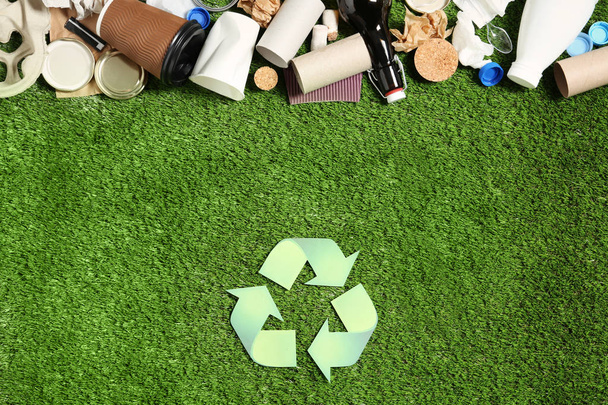 Recycling symbol and different garbage on synthetic turf - Фото, изображение