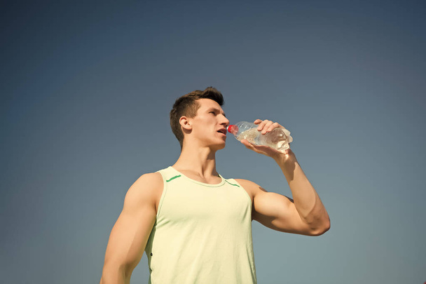 Man drinking water from bottle on sunny day - Photo, Image