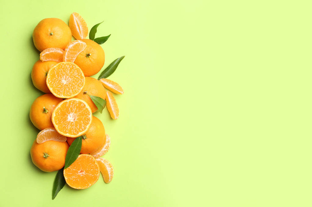 Composition with tangerines and leaves on color background, flat lay. Space for text - Photo, image