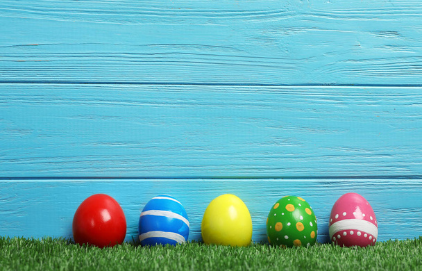 Decorated Easter eggs on green grass. Space for text - Zdjęcie, obraz